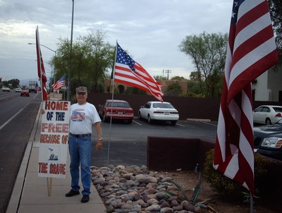 Frank with sign 'Home of the free because of the brave'