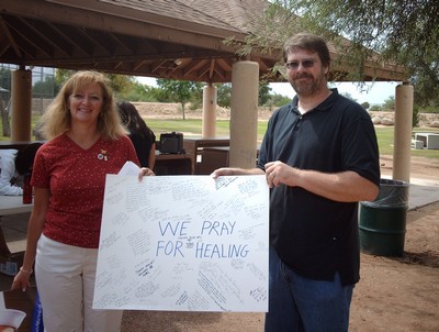 Rally Speaker Debbie Lee accepts a giant well wishing card for wounded troops from Tucson Pro-Americans