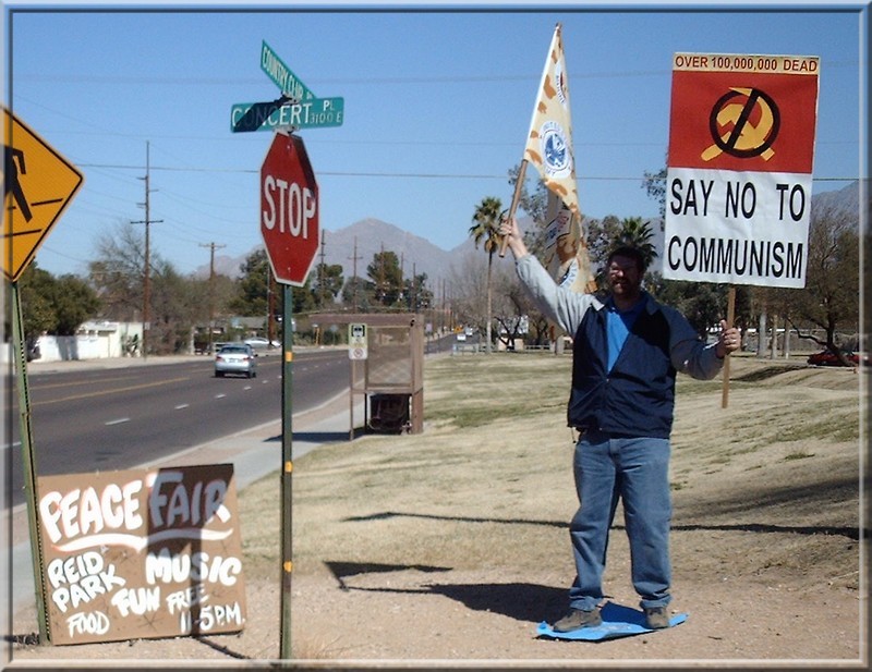 Wayne standing on a UN flag with 'say no to communism' sign